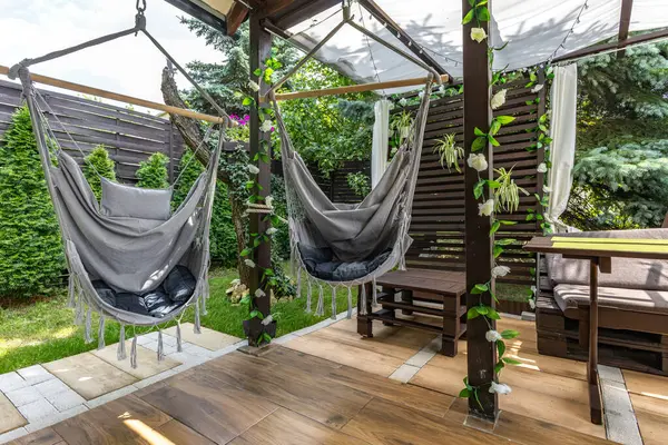 Sallanan hamak, verandada asılı gri Brezilya sandalyesi ahşap pergola, bahçede dinlenmek için bir yer.