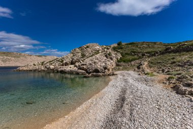 Resimli körfez ve Vela Luka 'dan Baska' ya uzanan turistik bir sahil olan KRK adasındaki çakıl taşı gibi boş Gnjilova plajı.
