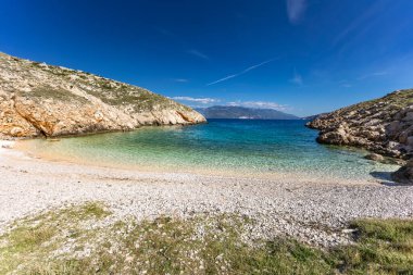 Resimli körfez ve Vela Luka 'dan Baska' ya uzanan turistik bir sahil olan KRK adasındaki çakıl taşı gibi boş Gnjilova plajı.