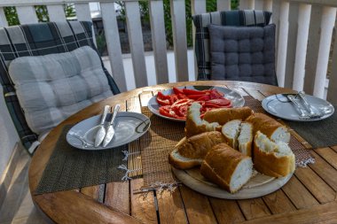 Taze dilimlenmiş ekmek, kırmızı olgun domates, apartmanın önündeki terasta Akdeniz kahvaltısı, beslenme yemeği.