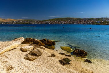 Hırvatistan 'ın Ciovo adasındaki Planikovica Plajı, çakıllı plaj, Adriyatik Denizi' nin masmavi rengi, boş beac