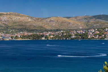Ciovo adasının panoraması, ufukta daireler, Ciov adasındaki körfezde yüksek hızda uçan jet skiler.
