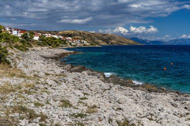 Hırvatistan 'ın Ciovo adasındaki Bulicicev plajına giden sahil yolu, masmavi su, boş plajlar, kayalıklarda gizlenmiş plajlar.