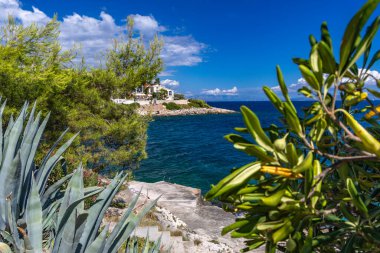 Hırvatistan 'ın Ciovo adasındaki Bulicicev plajına giden sahil yolu, masmavi su, boş plajlar, kayalıklarda gizlenmiş plajlar.