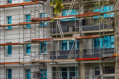 Yüksek bir binanın cephesine inşa edilmiş alüminyum yapı, yapay köpükle izole edilmiş duvarlar, bir apartman bloğunun yenilenmesi