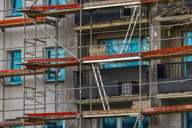 Yüksek bir binanın cephesine inşa edilmiş alüminyum yapı, yapay köpükle izole edilmiş duvarlar, bir apartman bloğunun yenilenmesi