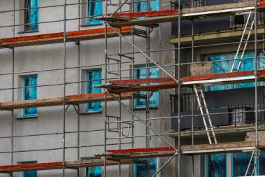 Yüksek bir binanın cephesine inşa edilmiş alüminyum yapı, yapay köpükle izole edilmiş duvarlar, bir apartman bloğunun yenilenmesi