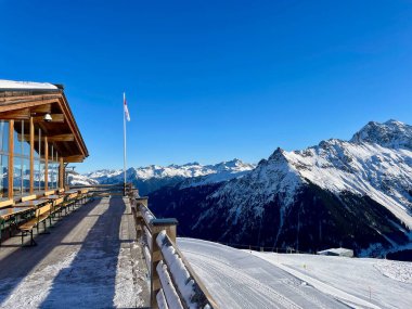 Güneşli bir kış gününde, Gargellen, Montafon, Vorarlberg 'deki dağların muhteşem manzaralı bir dağ restoranının terası. Yüksek kalite fotoğraf