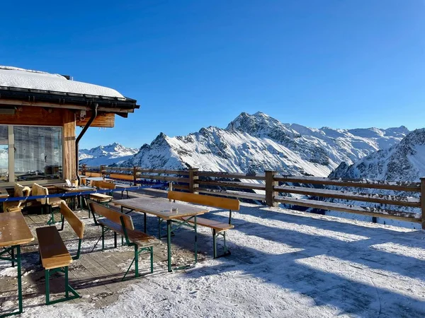Güneşli bir kış gününde, Gargellen, Avusturya 'daki dağların muhteşem manzaralı bir dağ restoranının terası..