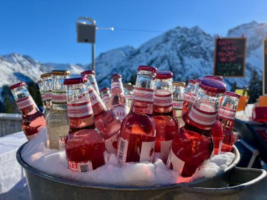 Apres Avusturya Alplerinde kayak yapıyor. Lillet şişeleri güneşli bir günde kovada. Brand, Vorarlberg, Avusturya, 13.01.2024. Yüksek kalite fotoğraf