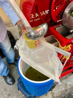 Medellin, Kolombiya, 12.07.2024 'te şeker kamışı suyunu plastik bardağa dolduran satıcıya yaklaş. Yüksek kalite fotoğraf