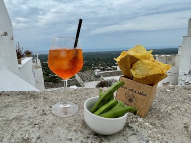 Borgo Antico Bistrot, Ostuni 'de Aperitivo. Taze fasulye ve cips ile Aperol Spritz Kokteyli. Puglia, İtalya, 13.04.2025. Yüksek kalite fotoğraf