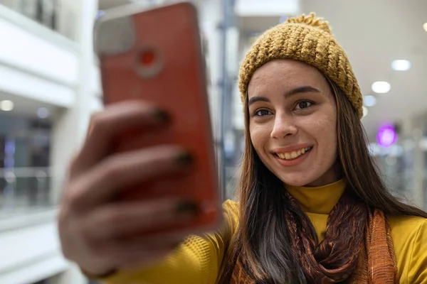 Young Latin American woman smiling and taking a selfie