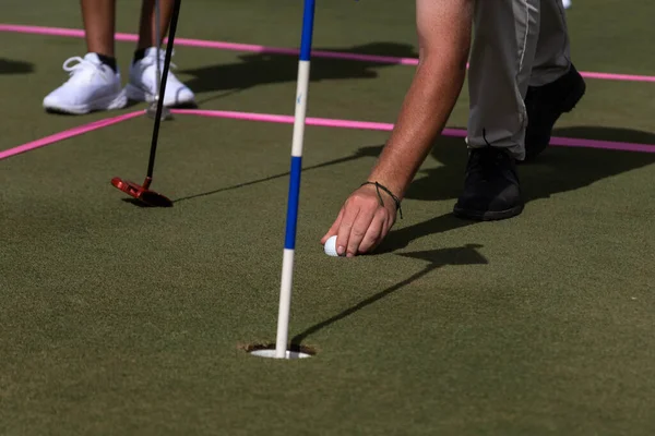 ゴルフインストラクターは 草の上にボールを配置する方法を教えています — ストック写真