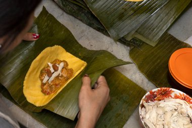 Preparation and ingredients of a Hallaca or tamale wrapped in banana leaf clipart