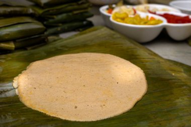 Corn dough spread on banana leaf, to prepare Hallaca or tamale clipart