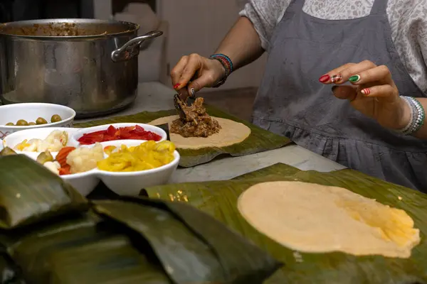 Muz yaprağına sarılı bir Hallaca ya da tamale 'nin hazırlanması ve malzemeleri.