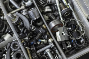 Vidaları, fındıkları ve motor parçaları olan alet çantası.