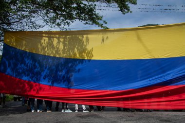 Venezuela bayrağının şeffaflığından görünen bir kalabalık. Birlik ve sivil ifadenin sembolü..