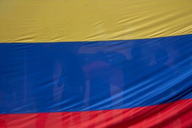 Venezuela bayrağının şeffaflığından görünen bir kalabalık. Birlik ve sivil ifadenin sembolü..
