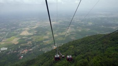 Yeşil orman manzarası üzerinde hareket eden kablo arabalar