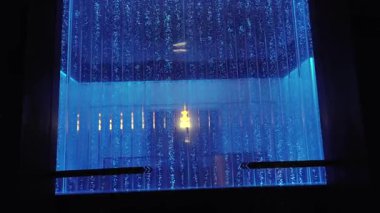 Şelale gibi akan mavi akarsuların ardında parlayan ışık.