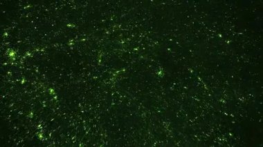 Koyu arkaplanda parlayan yeşil parçacıklar