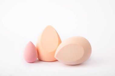 Güzellik karıştırıcısı beyaz arkaplanda izole edilmiş. Kozmetik için parlak süngerler. Makyaj ürünleri. Güzellik konsepti. ÇEVİRİ.