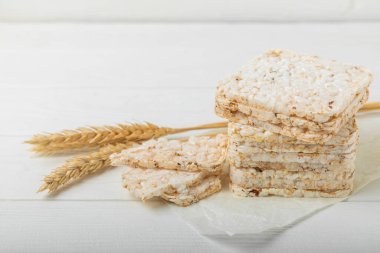 Yuvarlak pirinç kekleri ve çiviler beyaz ahşap bir masada. Kıtır ekmek. Pofuduk pirinç ekmeği. Diyet gevrek pirinç kekleri. Mesaj için uygun bir yer. Kopyalamak için yer. Sağlıklı yiyecekler. diyet ürünü.