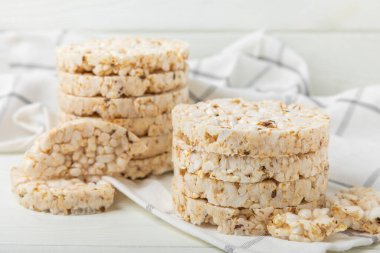 Beyaz ahşap bir masada yuvarlak pirinç kekleri. Kıtır ekmek. Pofuduk pirinç ekmeği. Diyet gevrek pirinç kekleri. Mesaj için uygun bir yer. Kopyalamak için yer. Sağlıklı yiyecekler. diyet ürünü.