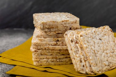 Siyah bir masada yuvarlak pirinç kekleri. Kıtır ekmek. Pofuduk pirinç ekmeği. Diyet gevrek pirinç kekleri. Mesaj için uygun bir yer. Kopyalamak için yer. Sağlıklı yiyecekler. diyet ürünü.