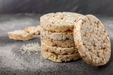 Siyah bir masada yuvarlak pirinç kekleri. Kıtır ekmek. Pofuduk pirinç ekmeği. Diyet gevrek pirinç kekleri. Mesaj için uygun bir yer. Kopyalamak için yer. Sağlıklı yiyecekler. diyet ürünü.