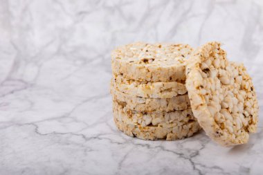 Mermer masada yuvarlak pirinç kekleri. Kıtır ekmek. Pofuduk pirinç ekmeği. Diyet gevrek pirinç kekleri. Mesaj için uygun bir yer. Kopyalamak için yer. Sağlıklı yiyecekler. diyet ürünü.