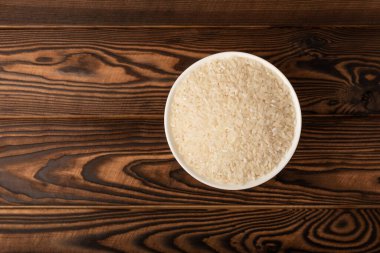 Sağlıklı yiyecekler. Kahverengi mermer arka planda bir kase pilav. Metin için yer, kopyalama alanı. Diyet lapası..