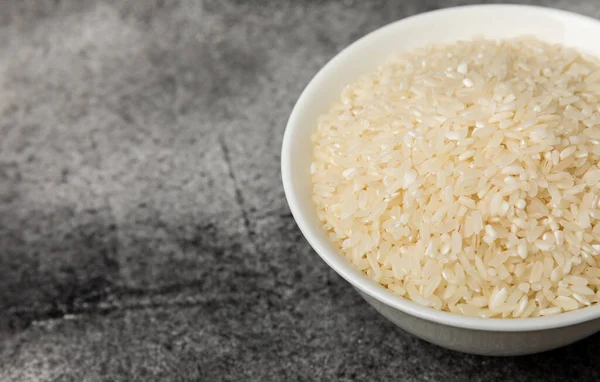 stock image Healthy food. A bowl of steamed rice on a black marble background. Place for text, copy space. Diet porridge.