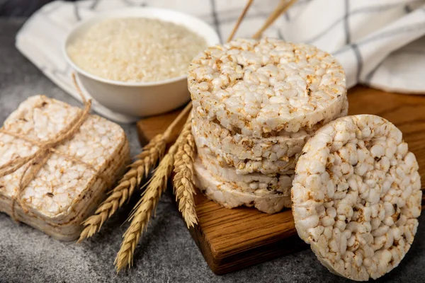 Round rice cakes and rice in a bowl on a  black table. Crispbread.Puffed rice bread. diet crispy round rice cakes.Place for text. Place for copy. Healthy food. dietary product
