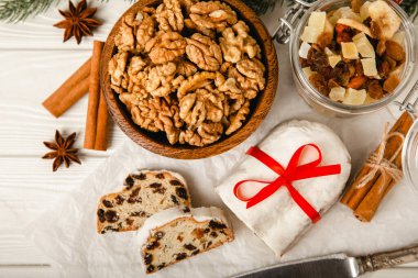 Noel çalıntısı beyaz ahşap bir masada geleneksel bir Alman ekmeğidir. Hamur, fındık ve badem ezmesi serpiştirilmiş pudra şekerli tatlı. Kopya alanı. Metin için yer.