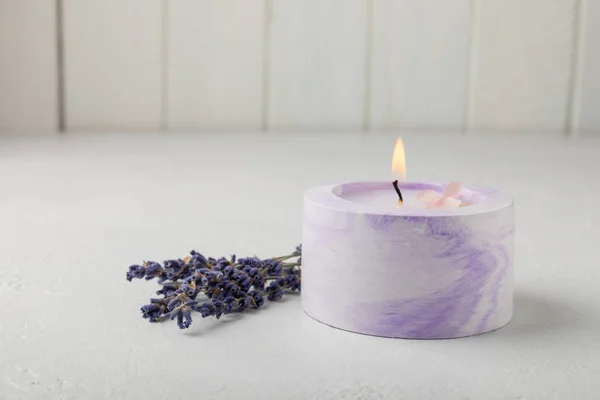 Candles. White soy candles in lilac flowerpots with lavender scent. Candle on a white texture background. Place for text. Place for copying. Spa candles with a pleasant aroma. Aromatherapy and relaxation.