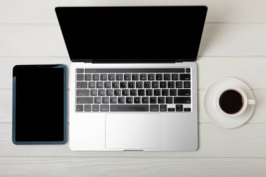 Modern çalışma alanı. Laptop, kahve fincanı ve akıllı telefon. Beyaz doku arkaplanının uzay modelini kopyala. Yukarıdan bak. Düz biçim.
