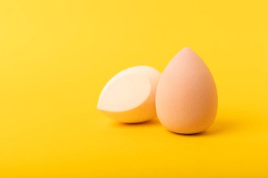 Güzellik karıştırıcı. Sarı arka planda kozmetik sünger. MOCAP. Vakıf ve kapatıcı için sünger. Güzellik konsepti. Mesaj için yer var. Kopyalama alanı.