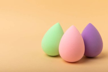 Güzellik karıştırıcı. Bej arka planda kozmetik sünger. MOCAP. Vakıf ve kapatıcı için sünger. Güzellik konsepti. Mesaj için yer var. Kopyalama alanı.