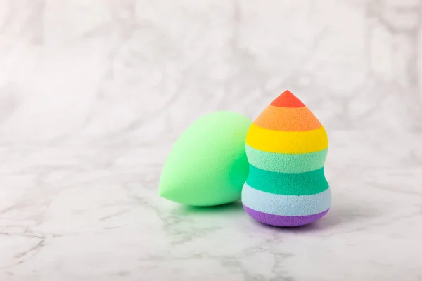 stock image Beauty blender. Cosmetic sponge on a white marble background. MOCAP. Sponge for applying foundation and concealer. Beauty concept. Space for text. Space for copy space.