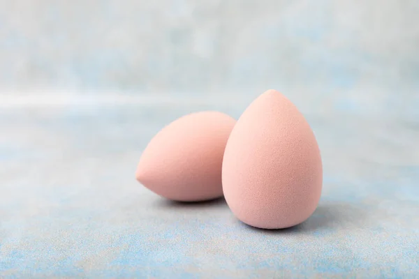 stock image Beauty blender. Cosmetic sponge on a blue marble background. MOCAP. Sponge for applying foundation and concealer. Beauty concept. Space for text. Space for copy space.