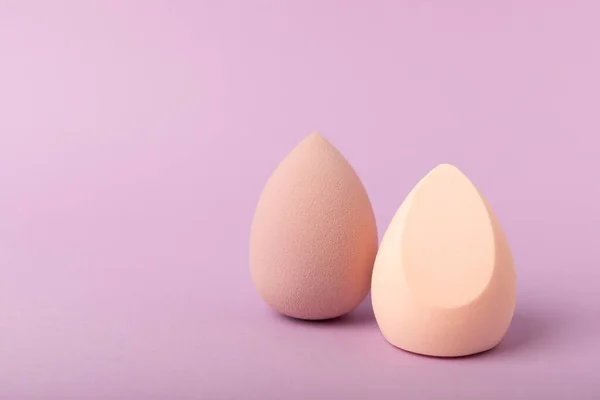 stock image Beauty blender. Cosmetic sponge on a lilac background. MOCAP. Sponge for applying foundation and concealer. Beauty concept. Space for text. Space for copy space.