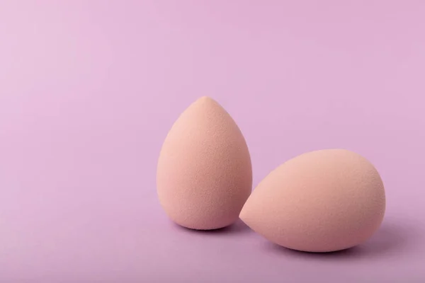 stock image Beauty blender. Cosmetic sponge on a lilac background. MOCAP. Sponge for applying foundation and concealer. Beauty concept. Space for text. Space for copy space.