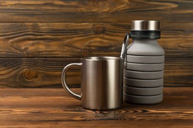 Arka planda turist ekipmanları var. EDC hazır. Düz plan. Su için termos ve seyahat kupası. Seyahat seti.