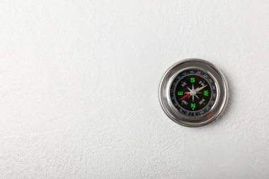 Beyaz dokuda klasik yuvarlak pusula. Pusula ile turizmin sembolü, pusula ve açık hava aktiviteleriyle seyahat etmek. Yakın plan. Mesaj için yer. Boşluğu kopyala