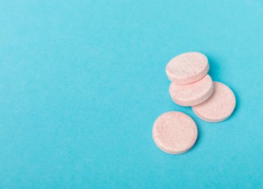 Mavi arka planda renkli tıbbi haplar. Vitaminler. Sağlık konsepti. Dokunulmazlık ilacı. Kopya için yer var. Metin için boşluk.