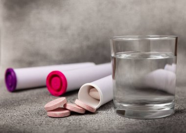 Fışkırtıcı tablet ve siyah desenli arka planda bir bardak su. Vitaminler. Sağlık konsepti. Dokunulmazlık ilacı. Kopya için yer var. Metin için boşluk.