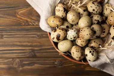 Koyu kahverengi ahşap arka planda bir tabakta bıldırcın yumurtası. Eko ürün. Diyet yemek. Sağlıklı yiyecekler. Metin için boşluk. Kopyalamak için boşluk.